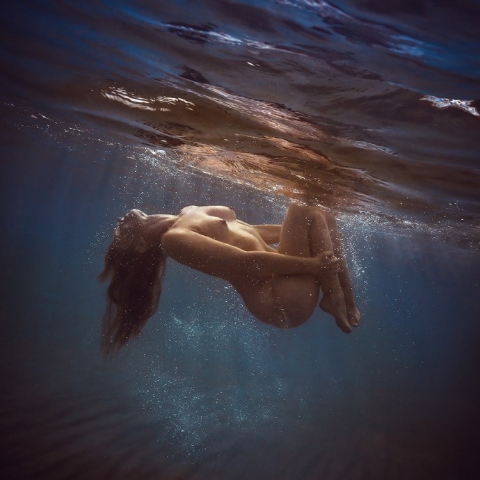 Naked female body in water