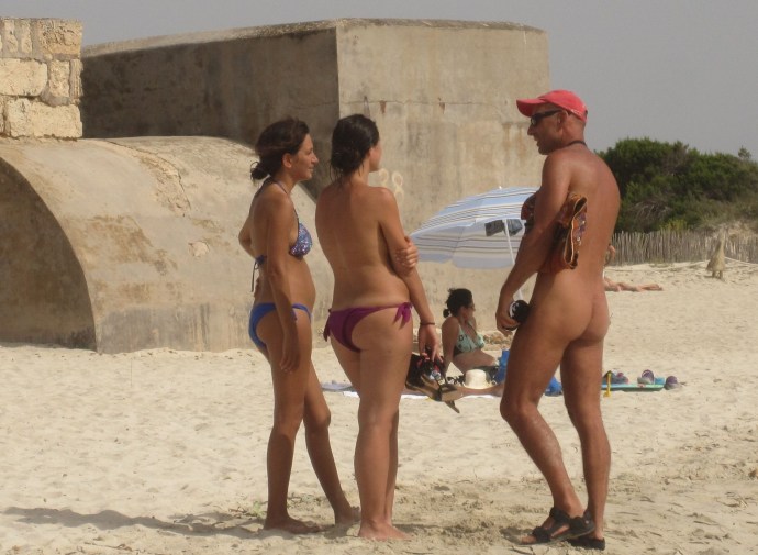 Naked women among men on the beach