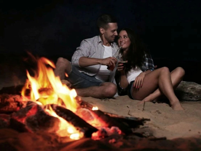 A guy with a girl by the fire